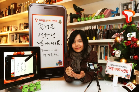 스마티(smarT) 라이프 SNS에세이를 연재하는 소설가 백영옥이 스마트폰 애플리케이션을 사용해 크리스마스 인사와 사인을 스마트폰 화면에 쓰고 있다. 좌측 모니터 화면은 갤럭시S로