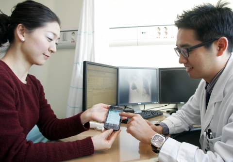서울아산병원을 방문한 한 환자가 담당의사와 함께 <내 손안의 차트> 앱을 이용해 자신의 검진 결과를 살펴보고 있다.