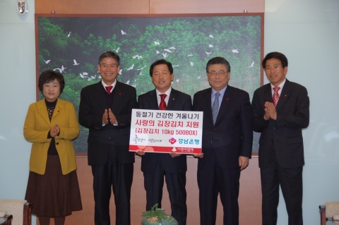 경남은행 이찬우 부행장(사진 오른쪽 세번째)이 박맹우 울산시장과 사회복지공동모금회 김상만 회장에게 ‘사랑의 김장김치 기증서’를 전달한 후 기념촬영하고 있다.
