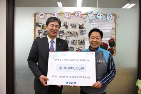 대우건설 서종욱 사장이 12월 29일 ‘대우건설 동전모아 사랑실천하기 캠페인’을 통해 마련된 대우건설 임직원들의 성금을 밥상공동체-연탄은행의 허기복 목사에게 전달하고 있다.