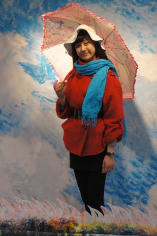 모네의 양산을 쓴 여인을  배경으로 관람객이 명화속 두인공과  같은 포드를 하고 사진을 찍고있다