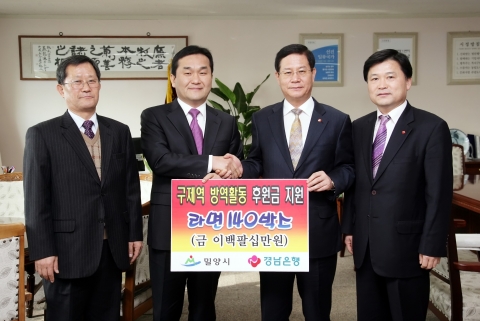 경남은행 조태구 동부본부장(사진 오른쪽 두번째)이 엄용수 밀양시장(사진 왼쪽 두번째)에게 ‘구제역 방역활동 후원금 기증서’를 전달한 후 기념촬영하고 있다.