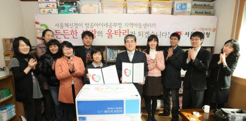 김상원 서울체신청 사업지원국장과 지역아동센터 센터장인 김복순 아네스수녀가 협약서에 서명한 후 재능기부 참여직원들과 기념촬영을 하고 있다.