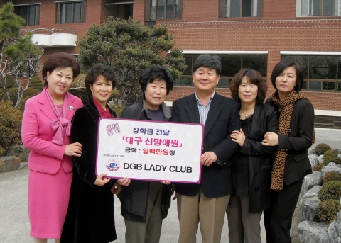 장학금을 전달하고 있는 DGB LADY CLUB 손태숙 회장(왼 쪽 세 번째), 대구 신망애원 송종철 원장 (오른쪽에서 세 번째)