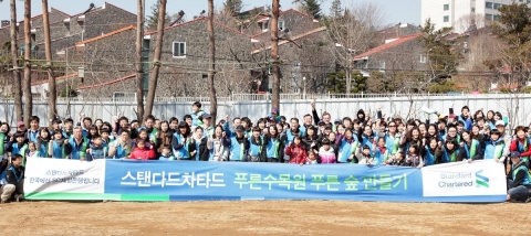 2011년 3월 26일 오전 서울 구로구 항동 서울푸른수목원에서 열린 다문화가정과 함께하는 푸른수목원 나무심기에 참여한 한국스탠다드차타드금융지주 임직원 300여명과 다문화 가정, 서울시민이 함께 기념촬영을 하고 있다.