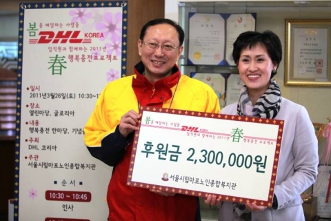 DHL KOREA 한병구 대표이사가 서울시립마포노인종합복지관 성미선 관장에게 DHL직원들의 월급 끝전 모으기 활동을 통해 모은 기금을 전달하고 있다.