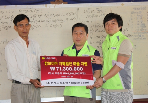 배상호 LG전자 노조위원장(가운데)이 캄보디아 자매결연을 맺은 트놀마을의 마을회관에서 지난해 전 사업장에서 노조원으로부터 자발적으로 모금한 지원금을 전달하고 있다.