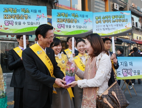 KB국민은행 민병덕 은행장(사진 왼쪽)과 임직원들이 5일 아침 서울 여의도역 출입구에서 출근하는 고객들에게 감사의 마음과 함께 봄맞이 탁상용 화분을 전달하고 있다. KB국민은행은  2만여 임직원들이 전국의 주변 상가와 인근 아파트 단지에서 새봄을 맞아 고객에게 탁상용 화분과 물티슈를 배부하는 봄맞이 캠페인을 오는 8일까지 펼친다.