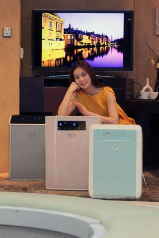 삼성전자 모델이 황사 내 유해물질을 효과적으로 제거해주고,  깨끗한 실내공기를 제공하는 2011년형 하우젠 공기청정기 신제품을 소개하고 있다
