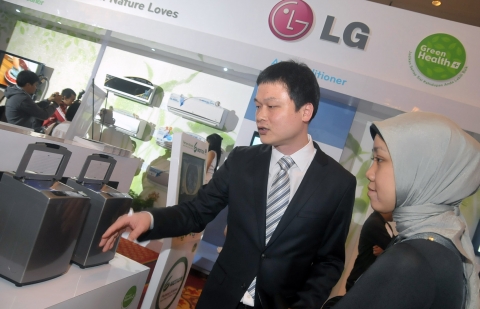 LG전자 '그린 헬스 플러스 캠페인'에서 직원이 현지 기자에게 6모션 데모 모형과 함께 친환경 신제품 세탁기 기능을 설명하고 있다.