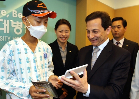 한국지엠 마이크 아카몬 사장이 14일, 인하대학교 병원을 방문해 백혈병으로 입원 치료를 받고 있는 성우 군을 격려하고 임직원 헌혈 캠페인을 통해 모은 헌혈 증서와 기부금 2천만원을 전달했다. 아카몬 사장이 성우 군에게 쉐보레 모자와 미니카를 선물하고 있다.