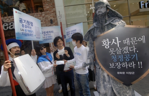 LG전자 모델들이 이순신 장군 동상과 포졸로 분장하고 명동에 등장했다. 본격적인 황사철에 청정한 공기 보장하라는 시위 퍼포먼스에 시민들이 동참하고 있다.