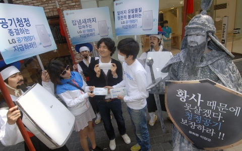 LG전자 모델들이 이순신 장군 동상과 포졸로 분장하고 명동에 등장했다. 본격적인 황사철에 청정한 공기 보장하라는 시위 퍼포먼스에 시민들이 동참하고 있다.