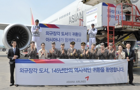 14일 인천공항에 도착한 아시아나항공 OZ502편에서 내려진 외규장각 도서 1차 반환분앞에서 본 항공기에 탑승한 아시아나 운항 및 캐빈승무원과 공항직원들이 기념촬영을 하고 있다.