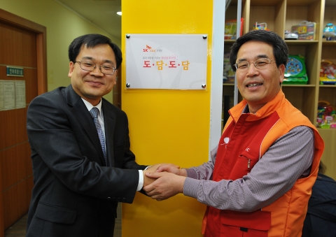 SK C&C 경영지원부문장 조영호 전무(사진 오른쪽)와 곽상구 성남시 장애인종합복지관장(사진 왼쪽)이 19일 경기도 성남시 중원구 성남시 장애인종합복지관에서 성남시 최초의 장애 아동 도서관 ‘도담도담’ 개관식 행사 후 기념촬영을 하는 모습