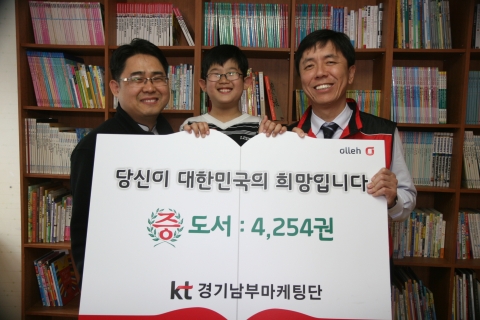 KT 경기남부마케팅단 사랑의 봉사단은 세계 책의 날(4월 23일)을 맞아 신간도서와 직원들이 기증한 도서 등 총 4,254권을 결연된 22개 지역아동센터에 전달하고 기증식을 가지고 있다. 좌측부터 수원소망지역아동센터 이경석 센터장, 소망지역아동센터 아동 이하진, KT 경기남무마케팅단 정준수 단장