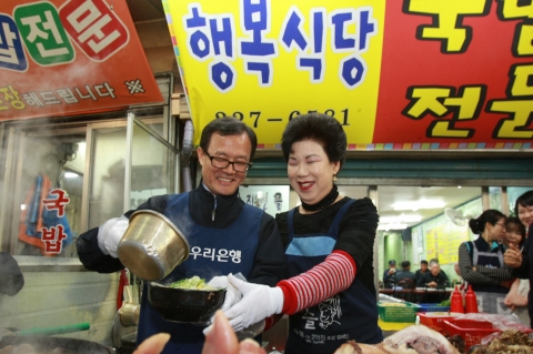 이순우 우리은행장이 26일 광주광역시 남광주시장 소재 미소금융 수혜자를 방문해 격려하고 음식준비를 도우고 있다.