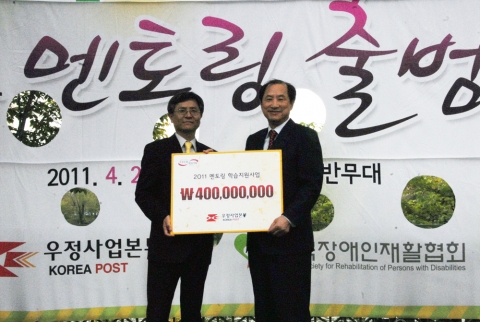 '2011 장애가정 청소년 멘토링 학습지원사업' 출범식이 29일 잠실의 한 놀이공원에서 열려 김명룡우정사업본부장(왼쪽)이 이상철 한국장애인재활협회장에게 지원금을 