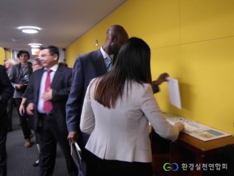 UN 제19차 지속가능발전위원회 정규session의  Information Booth에서 자료를 가져가는 회의 관계자들