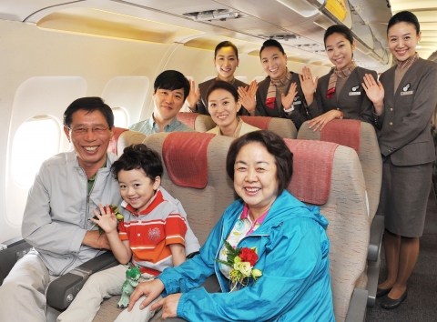 아시아나 『효(孝) 서비스』를 통해 선호좌석을 배정받은 부모님 동반 탑승객들이 기내에서 아시아나 승무원들과 기념촬영을 하고 있다.