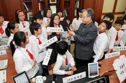 KT 이석채 회장이 어린이날을 맞아 4일 지역아동센터 어린이 23명을 KT 광화문 사옥에 초청하여, 회장 집무실에서 아이패드로 업무 처리하는 것을 보여주고 있다.