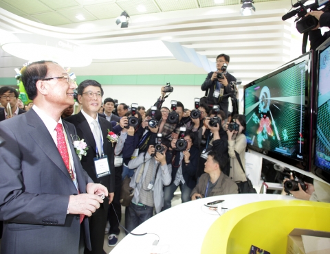 방송통신위원회 최시중 위원장(사진 왼쪽)과 SK텔레콤 하성민 사장(사진 오른쪽)이 5월 11일 개막한 WIS2011의 SK텔레콤 부스를 방문하여 LTE 기술을 체험해보고 있다.