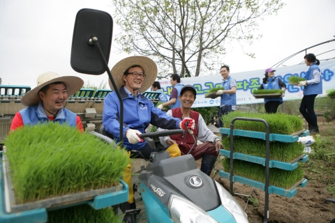 이순우 우리은행장(중앙)과 임혁 우리은행 노조위원장(좌측)이 박사영 유별난 마을 이장(우측)과 함께 이앙기로 모내기를 하고 있다.
