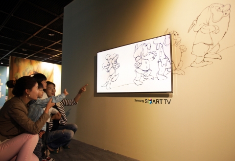 예술의전당에서 열리고 있는 월트디즈니 특별전에서 관람객들이 시크릿디자인이 적용된 삼성 스마트TV를 통해 애니메이션들을 감상하고 있다.