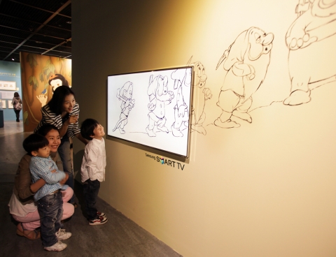 예술의전당에서 열리고 있는 월트디즈니 특별전에서 관람객들이 시크릿디자인이 적용된 삼성 스마트TV를 통해 애니메이션들을 감상하고 있다.