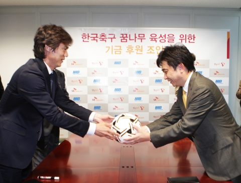 한국 축구 꿈나무 육성을 위한 기금 후원 조인식을 체결한 후 SK텔레콤 서진우 플랫폼 사장(우)에게 축구공(싸인볼)을 건네는 홍명보 이사장(좌)