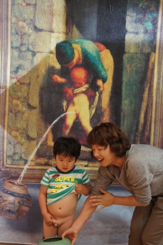 밀레의;어머니와 아들&#039;패러디 작품앞에서 실제로 어머니와 아들이 명화속의 주인공처럼 소변보는 모습을 해보이고 있다