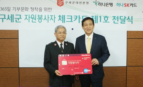 하나은행 김정태 은행장(사진 오른쪽)은 구세군 박만희 사령관에게 &#039;하나SK 구세군 자원봉사자 체크카드&#039;의 제1호 카드를 전달하였다.