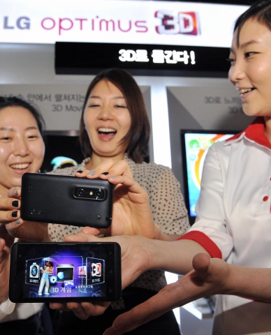 LG전자가 헐리우드 화제작 ‘트랜스포머 3’ 개봉에 앞서 28일 저녁 상암 CGV에서 ‘옵티머스 3D와 함께하는 트랜스포머3 시사회’를 가졌다. 이날 시사회에 참석한 여성 고객들이 '옵티머스 3D'를 체험해 보고 있다.