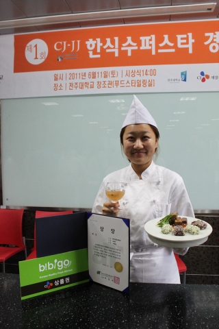 제 1회 CJ-JJ 한식수퍼스타 경연대회에서 대상을 수상한 배보람(대구카톨릭대학교 식품영양학과 4학년)양이 수상작 ‘된장소스 맥적 스테이크와 취나물 주먹밥’을 들고 기뻐하고 있다.