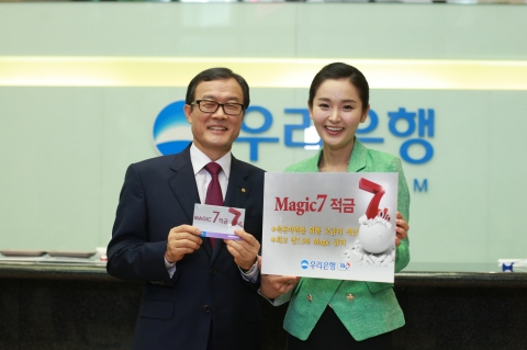이순우 우리은행장이 회현동 본점 영업부에서 최고 연 7%의 금리를 제공하는 ‘Magic 7 적금’을 1호로 가입하고 직원과 기념 촬영을 하고 있다.