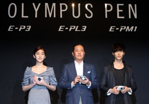 올림푸스한국(대표: 방일석)이 5일 오전 서울 웨스틴조선호텔에서 총 3종의 PEN 신제품(E-P3, E-PL3, E-PM1) 출시를 기념하여 신제품 발표회를 열었다. 이번 신제품은 세계 초고속 AF(오토 포커싱)와 새로운 센서 및 이미지 엔진으로 최상의 화질을 구현한 플래그십 모델 E-P3, PEN 라인 중 최초로 틸트 LCD를 장착한 PEN E-PL3, 그리고 215g의 세계 최경량 바디 및 핑크, 퍼플 등 화사한 컬러의 PEN 미니(PEN E-PM1)이다. 행사장을 찾은 (왼쪽부터)왕지원, 방일석 사장, 원빈