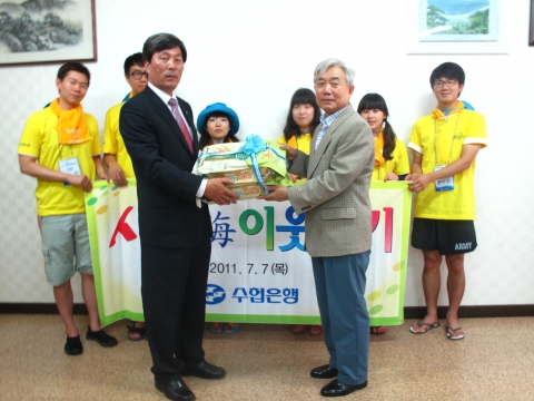 7월 7일 이주형 은행장이 대학생 어촌봉사단원들과 함께 진도군수협 조합장실에서 김상호 조합장에게 사랑海 쌀을 전달하고 있다.