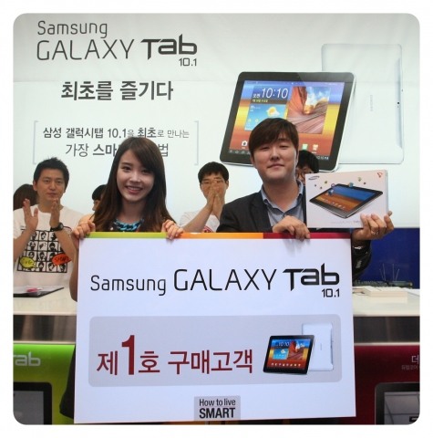 27시간을 기다려 국내 최초 ‘갤럭시탭 10.1’을 개통하게 된 박경민(36, 유통업)씨가 삼성전자 모델 아이유와 함께 사진을 촬영하는 영광을 누리고 있다.