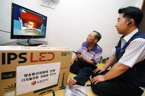 21일 서울 용두동 최돈한 고객이 '디지털 전환 취약계층 지원 사업'을 통해 구입한 LG전자 LED TV를 설치후  LG전자 설치기사로부터 제품 사용법에 대한 설명을 듣고 있다.