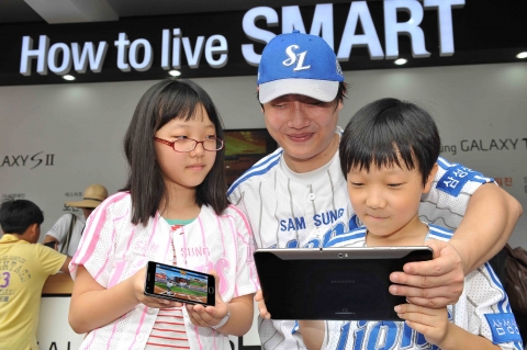 프로야구 팬 페스티벌이 열린 잠실 주경기장에서 23일 '삼성 스마트 체험존'을 찾은 한 가족이 갤럭시 시리즈로 야구게임을 해보며 즐거운 시간을 보냈다.