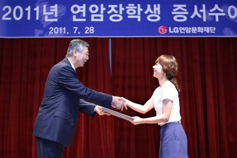강유식 (주)LG 부회장(왼쪽)이 대표장학생 이화여자대학교 심리학과 석사과정 심기선양에게 장학증서를 전달하고 있다.