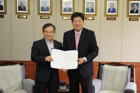 유태환 한국전기연구원장(좌)과 박천진 대한전기협회 부회장(우)가 나란히 서서 쌍방 간의 협정서를 펼쳐 보이고 있다.