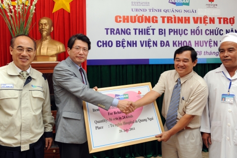 두산비나 류항하 법인장과 중앙대의료원 박인원 기획조정실장(왼쪽에서 두번째)이 베트남 꽝응아이성 응우엔 반 민(Nguyen Van Minh) 보건 국장에게(왼쪽에서 세번째) 재활 의료장비 기증 증서를 전달하고 있다