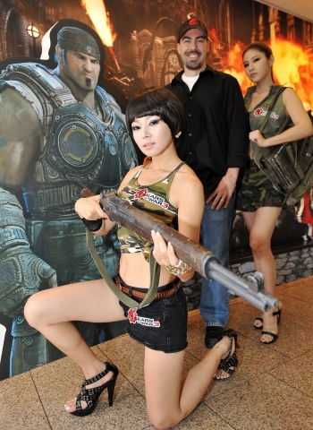 8월 22일 강남 섬유센터에서 열린 ‘기어스 오브 워3(Gears Of War3)’ 출시 행사에서 개발자 짐 브라운(가운데)과 모델들이 포즈를 취하고 있다.