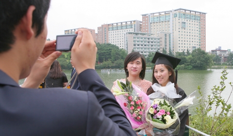 22일 오전 서울 광진구 화양동 건국대에서 열린 2011학년도 후기 학위수여식에서 졸업생들이 건국대 캠퍼스 대형 호수인 일감호에 설치된 전망대에서 호수와 태양광 백조 ‘솔라스완’을 배경으로 기념 촬영을 하고 있다.