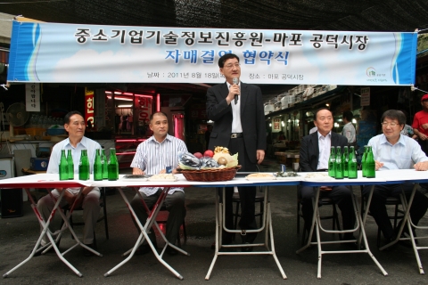 중소기업기술정보진흥원 윤도근 원장이 지난 8월 18일 열린 마포 공덕시장과 자매결연 협약식에서 임직원들에게 전통시장 활성화에 앞장서 줄 것을 당부하고 있다. (좌측부터 마포공덕시장상인회 장승철 고문, 박종서 회장, 중소기업기술정보진흥원 윤도근 원장, 박찬홍 전략기획실장, 오왕섭 경영정보지원본부장)