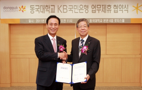 KB국민은행과 동국대학교는 9월 23일 서울 중구 필동 소재 동국대학교 본관에서 향후 10년 간의 포괄적인 주거래은행 업무제휴 협약을 체결하였다. 이번 협약으로 KB국민은행은 동국대학교 일산병원 내에 출장소 및 자동화기기를 설치하고 각종 금융 서비스를 제공하게 된다. 협약체결후 민병덕 은행장(사진 왼쪽)과 김희옥 총장(사진 오른쪽)이 악수하고 있다.