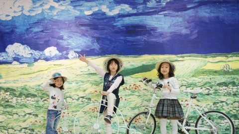 초대형으로 제작한 고흐의'폭풍아래 밀밭'에서 어린이 관람객들이 클래식자전거를 타고 즐거워하고 있다