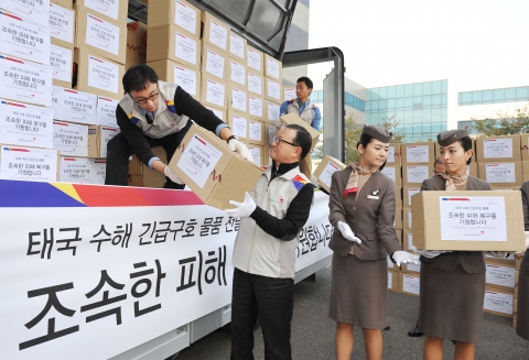 28일 서울 강서구 오쇠동 아시아나항공 본사에서 아시아나항공 윤영두 사장(좌측 두번째)과 임직원들이 태국 수해지역 주민들에게 전달할 구호물품들을 트럭에 싣고 있다.