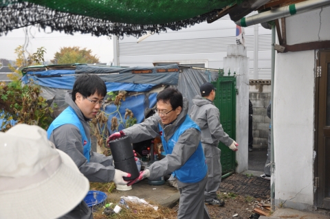 한국석유공사 강영원사장(오른쪽)이 연탄을 나르고 있다